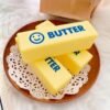 NeeDoh Butter Squishy realistic slow-rise butter stick toy in hand — Image 10 of 12