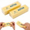 NeeDoh Butter Squishy realistic slow-rise butter stick toy in hand — Image 1 of 12